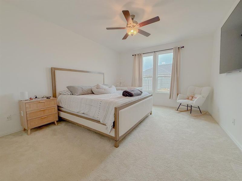 Bedroom with ceiling fan and light colored carpet