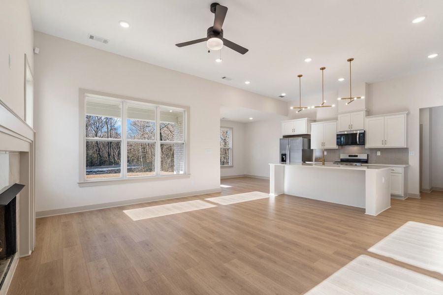 Unfurnished living room with ceiling fan, a fireplace, light wood-style floors, and recessed lighting