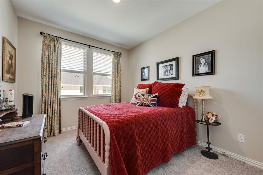 Bedroom featuring light carpet and baseboards