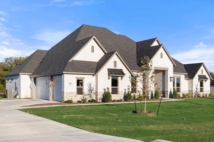 View of front of property with central AC, a garage, and a front lawn