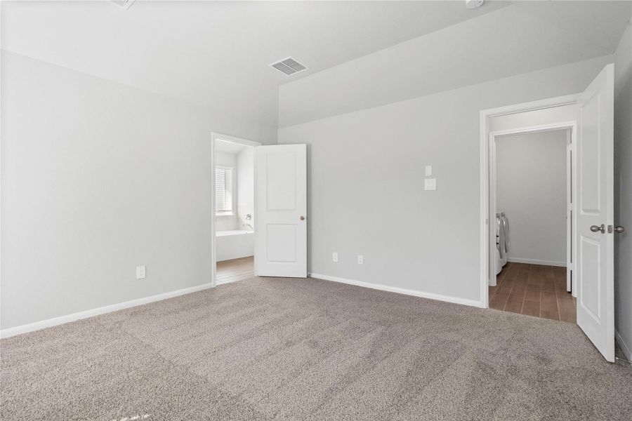 The private primary suite efficiently connects the sleeping area with the dedicated bathroom and generous closet. Note: Location of laundry room - directly across the primary bedroom entry door.