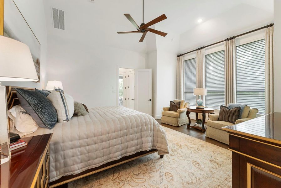 The primary suite is spacious and thoughtfully designed with window placement selected for privacy and improved furniture layout. Custom window coverings soften the light while maintaining a peaceful retreat feel.