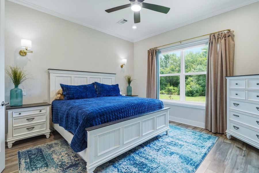 Primary bedroom with sconces, ceiling fan and double window overlooking the property Primary bedroom with sconces, ceiling fan and double window overlooking the property