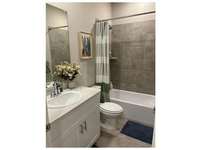 Full bathroom featuring tile patterned flooring, vanity, shower / bath combo, and toilet