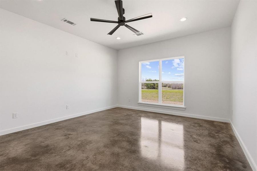 This room features bright white walls, polished concrete flooring, and a large window providing views of the outdoors