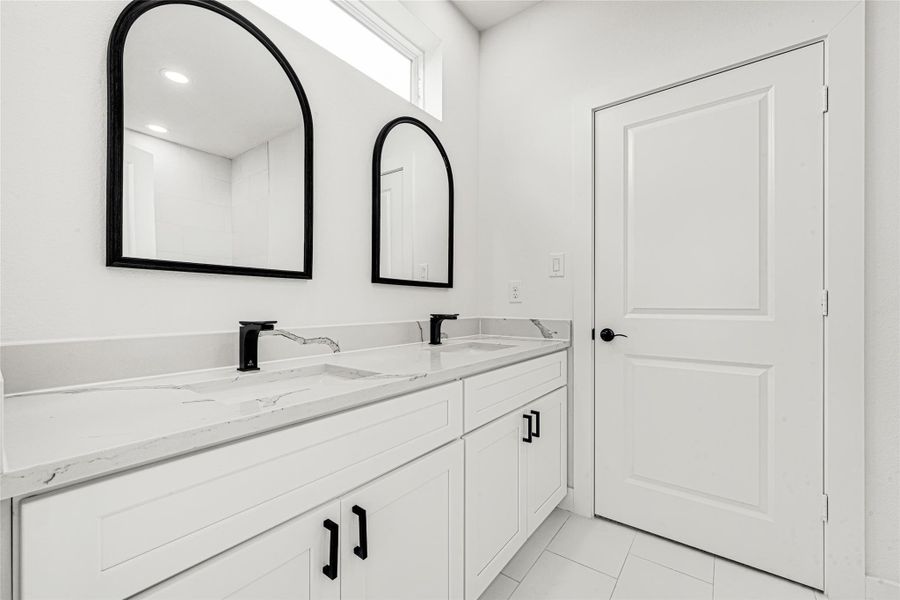 Stunning Jack and Jill bathroom shared between secondary bedrooms with a large dual-sink vanity and modern finishes.