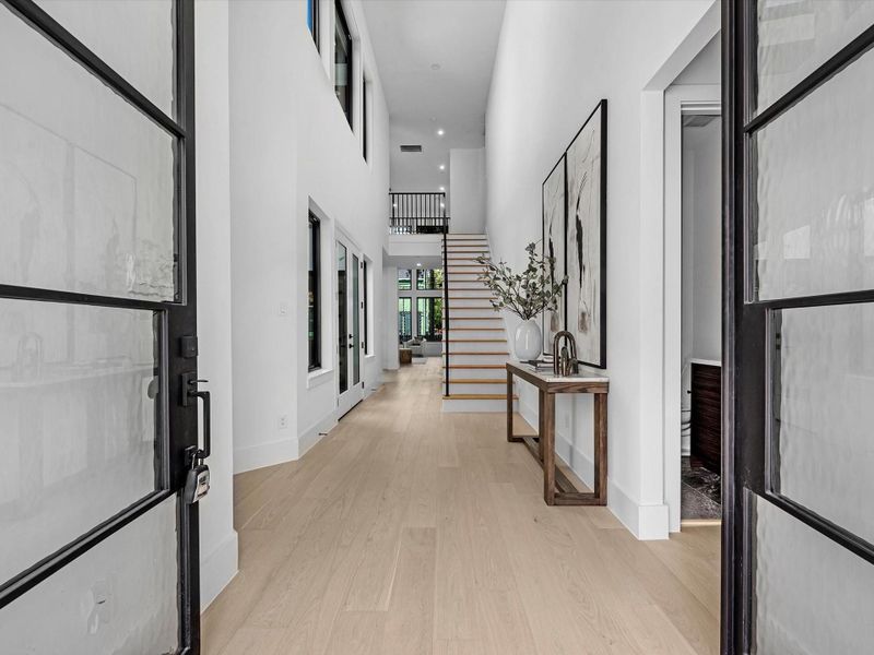 Step through the stunning double doors into a breathtaking open floor plan highlighted by soaring ceilings and walls of windows that fill the home with natural light. Just off the entry, a private study offers the perfect retreat for work or quiet focus.