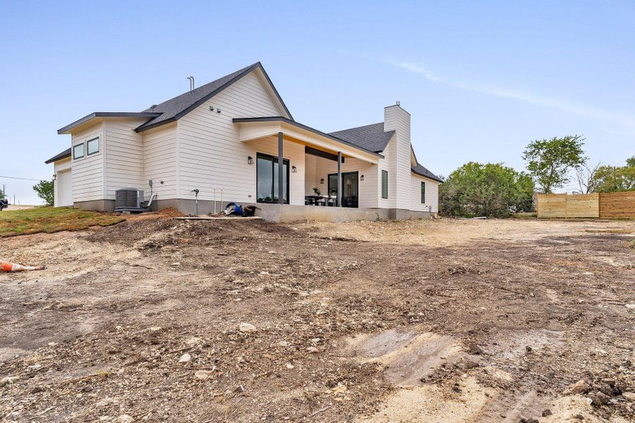 A modern farmhouse-style residence with a covered patio, ready for personalized landscaping to complete its charm. A modern farmhouse-style residence with a covered patio, ready for personalized landscaping to complete its charm.