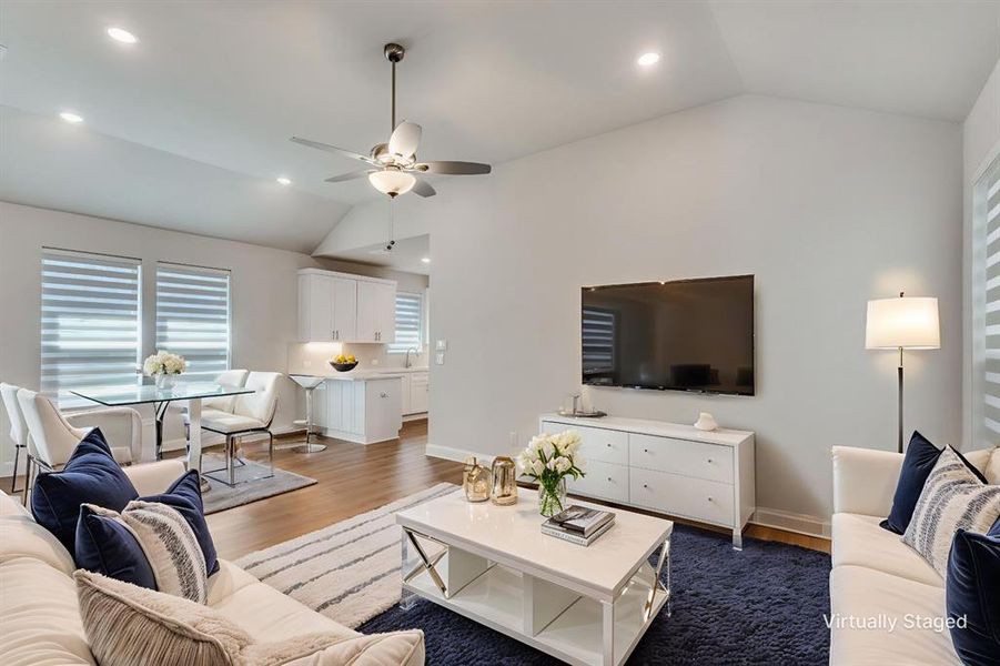 Living area featuring dark wood-style floors, lofted ceiling, ceiling fan, and recessed lighting Living area featuring dark wood-style floors, lofted ceiling, ceiling fan, and recessed lighting