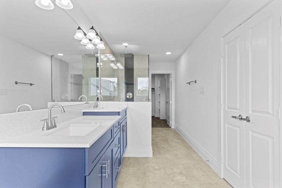 The spa primary bathroom has beautiful quartz countertops and backsplash with deep undermount his and hers private sinks.  Notice all the custom hardware this home has throughout the home, the door handles, the hardware and more!