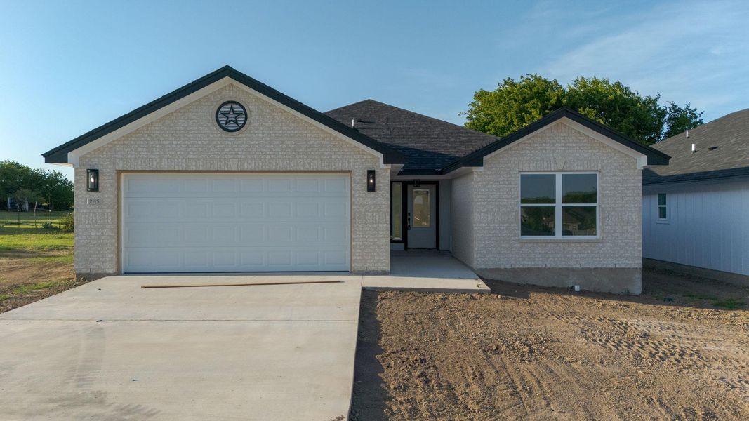 Single story home featuring brick siding, driveway, and an attached garage Single story home featuring brick siding, driveway, and an attached garage