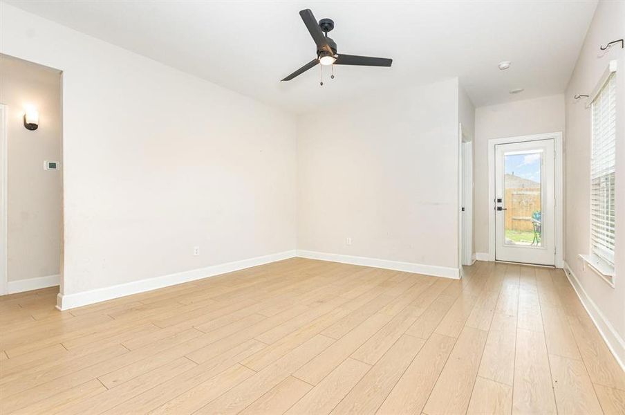 Empty room with ceiling fan and light wood-style flooring Empty room with ceiling fan and light wood-style flooring