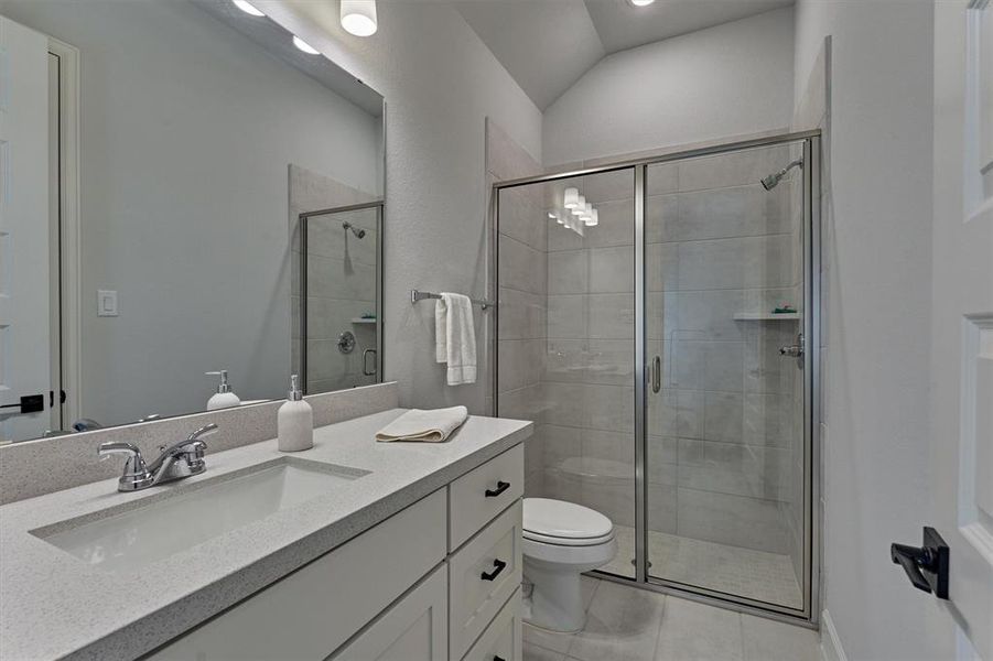 Guest suite offers expansive raised vanity for storage. Note the walk-in shower for added convenience.