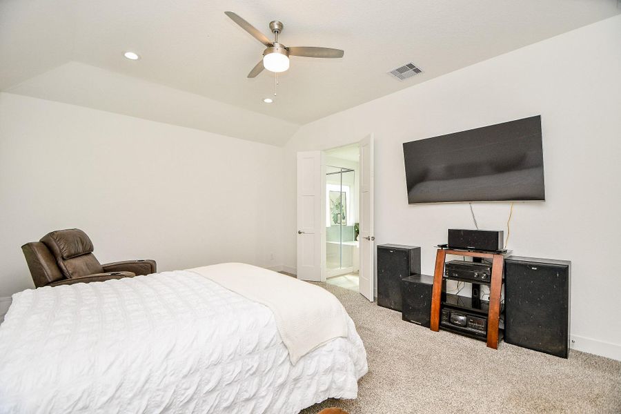 The primary bedroom features neutral walls and carpet, ample living space and ceiling ceiling fan. A doorway leads to an en-suite bathroom. The primary bedroom features neutral walls and carpet, ample living space and ceiling ceiling fan. A doorway leads to an en-suite bathroom.