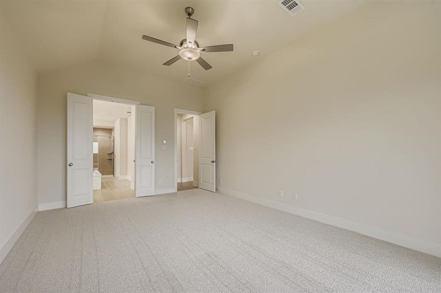 Unfurnished bedroom with light carpet, lofted ceiling, and a ceiling fan