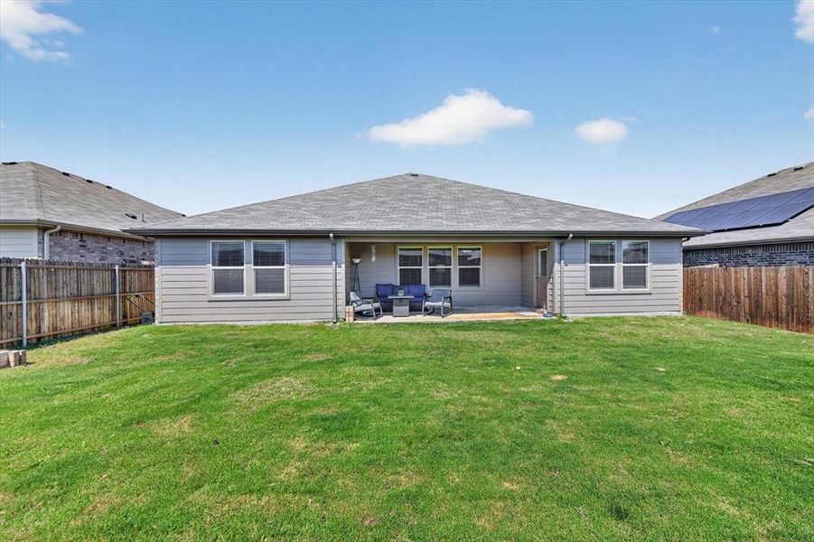 Expansive green lawn with a covered patio