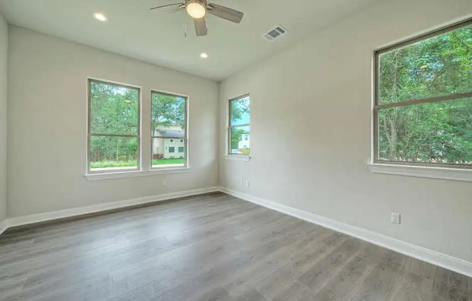 Empty room featuring ceiling fan, wood finished floors, and recessed lighting