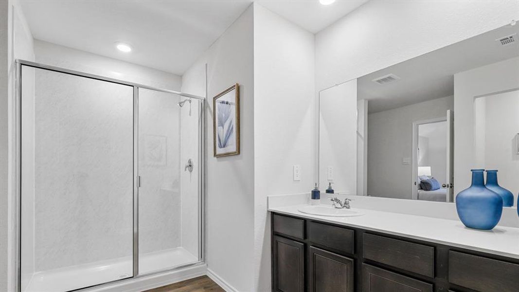 Ensuite bathroom featuring vanity, a stall shower, dark wood-style floors, and recessed lighting Ensuite bathroom featuring vanity, a stall shower, dark wood-style floors, and recessed lighting