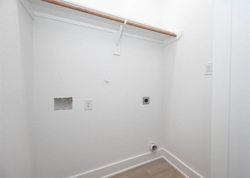 Dedicated utility room with washer and dryer connections and built-in storage space.