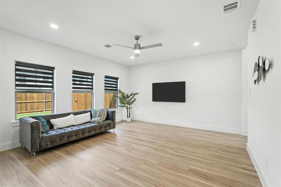 Living area with light wood finished floors, recessed lighting, and ceiling fan