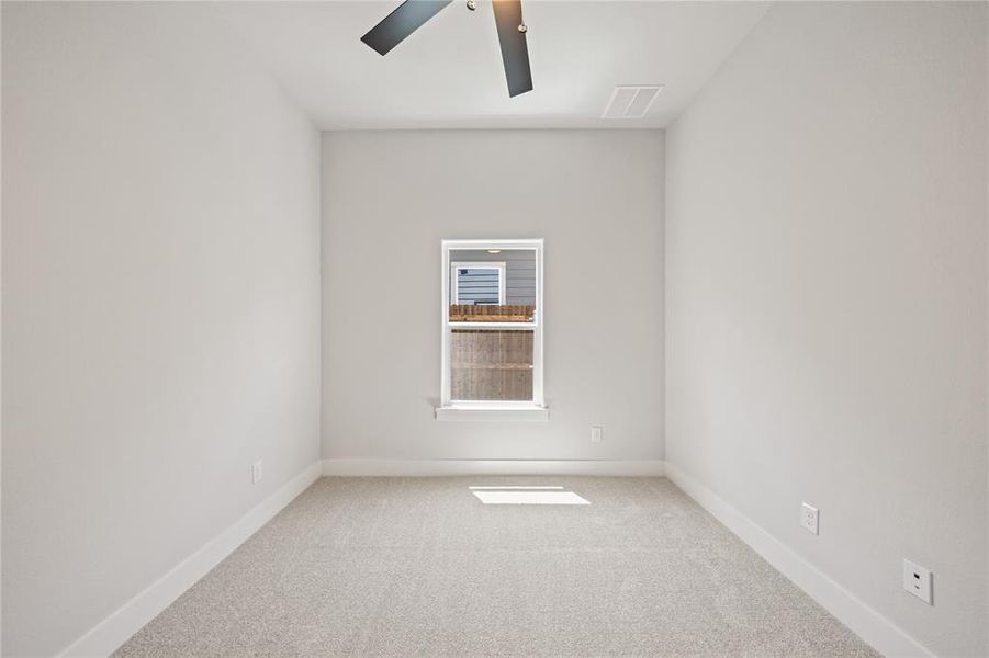 Carpeted interior space featuring a single window and a ceiling fan with integrated lighting