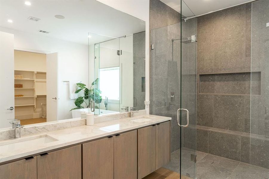 Bathroom with walk in shower, oversized vanity, and dual sinks Bathroom with walk in shower, oversized vanity, and dual sinks