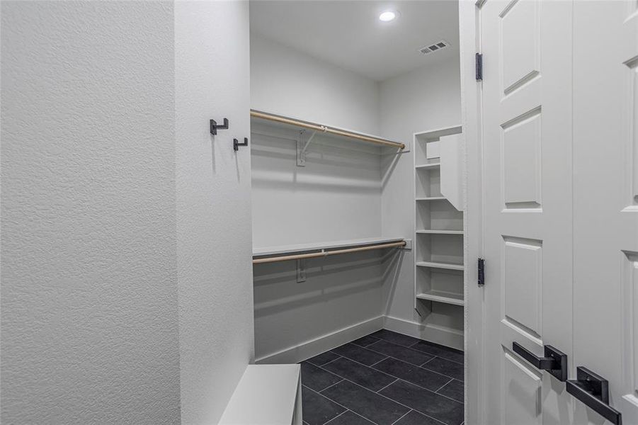 Spacious closet with dark tile patterned floors