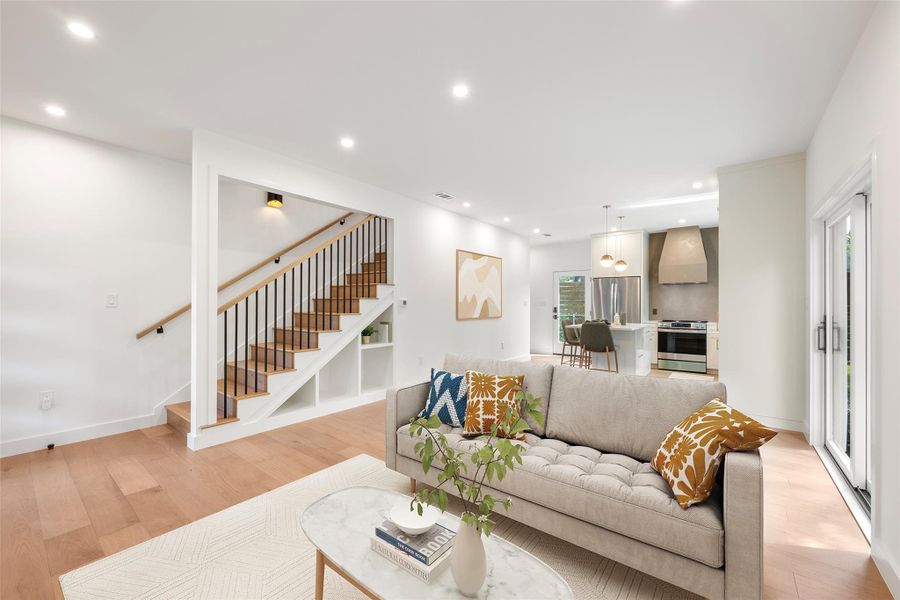 An open-concept living space integrates a well-appointed kitchen and a staircase with sleek railings. An open-concept living space integrates a well-appointed kitchen and a staircase with sleek railings.