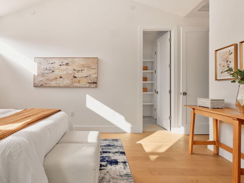 Bedroom with light wood-type flooring and lofted ceiling