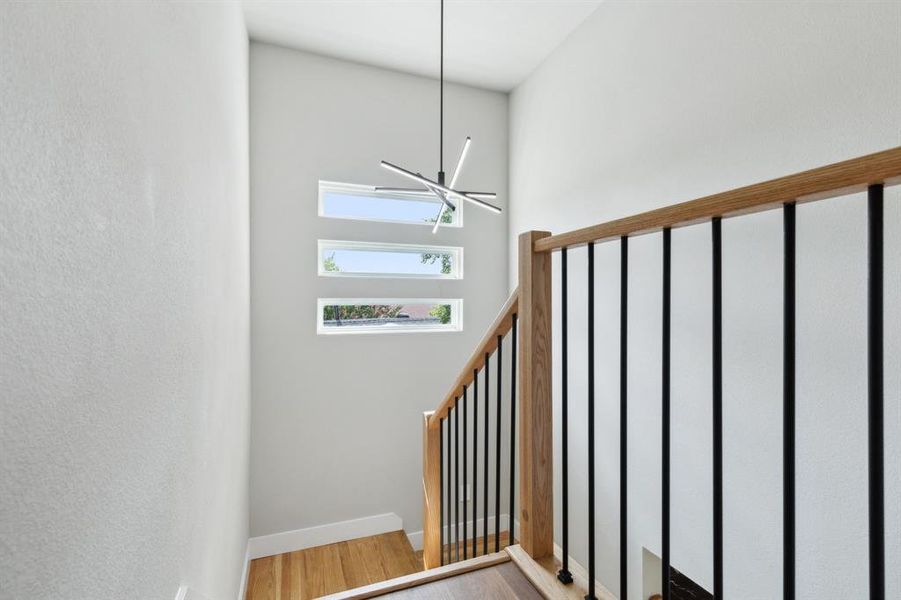 Stairs featuring hardwood / wood-style floors and a towering ceiling