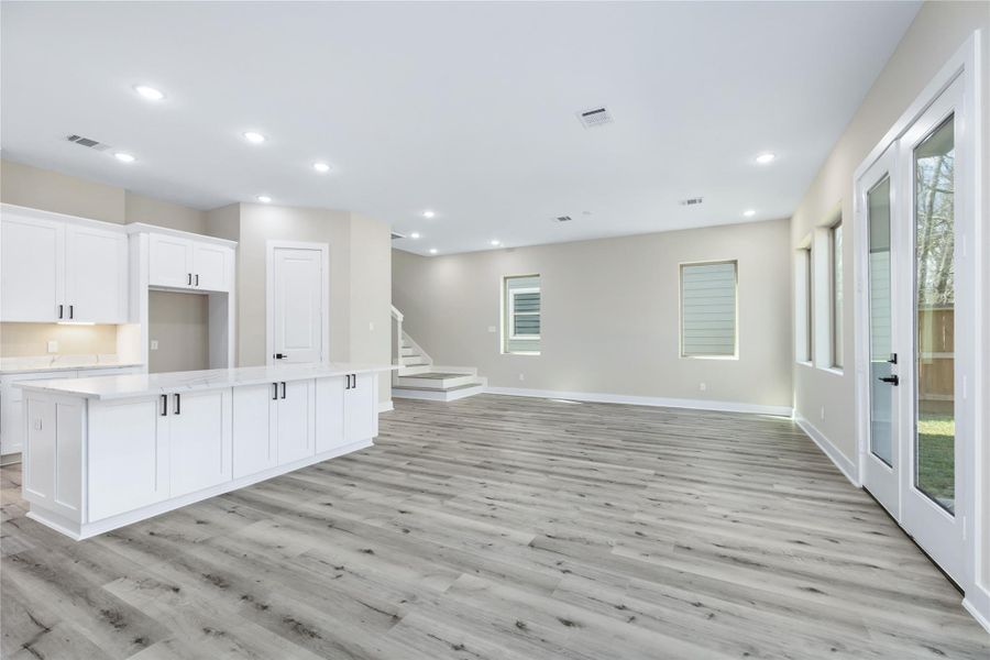 The whole home is brightly lit with recessed lighting and flooded with natural light from the large windows and glass doors leading to the backyard.