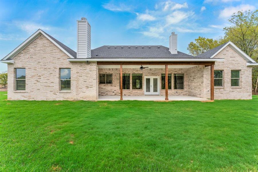 Rear view of house featuring a patio area, a lawn, and ceiling fan