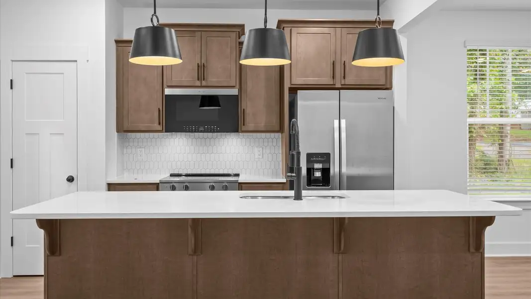 Exclusive DRB Homes kitchen with a 9-foot island, elevated finishes, and pendant lighting in a prime location Exclusive DRB Homes kitchen with a 9-foot island, elevated finishes, and pendant lighting in a prime location