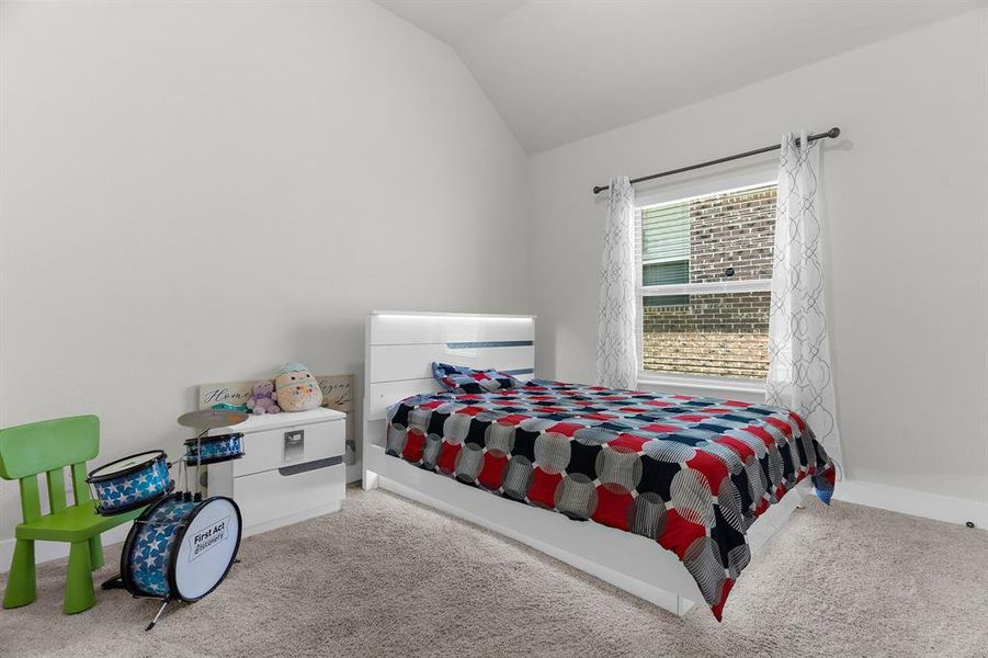 Carpeted bedroom featuring lofted ceiling and baseboards Carpeted bedroom featuring lofted ceiling and baseboards