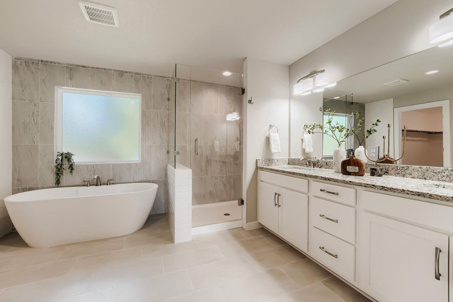 Luxurious primary bath featuring a freestanding soaking tub and expansive double vanity with ample storage. Luxurious primary bath featuring a freestanding soaking tub and expansive double vanity with ample storage.