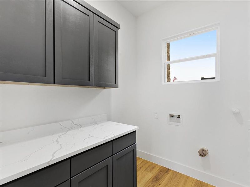 Laundry room with cabinet space, light wood-style floors, washer hookup, and gas dryer hookup Laundry room with cabinet space, light wood-style floors, washer hookup, and gas dryer hookup