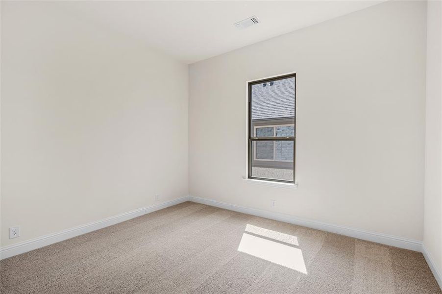 Empty room featuring light carpet and baseboards Empty room featuring light carpet and baseboards