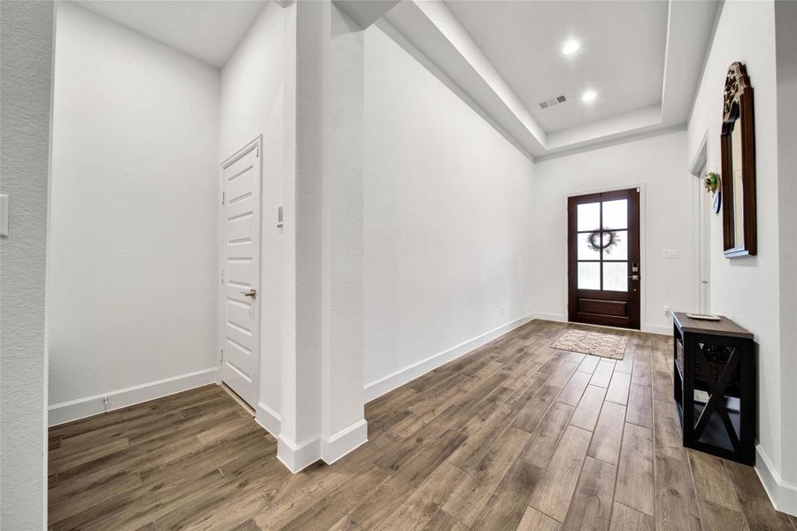 Welcoming entry with soaring 12' ceiling and durable wood-look tile flooring that continues through the main living areas.