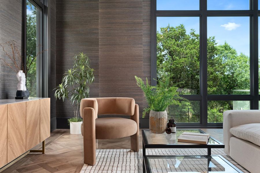 Floor-to-ceiling windows flood this modern living space with natural light and tree-filled views.