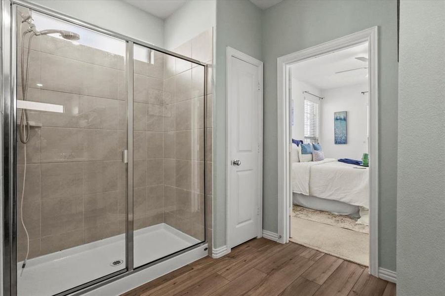 Bathroom featuring healthy amount of natural light, a shower stall, and wood finished floors Bathroom featuring healthy amount of natural light, a shower stall, and wood finished floors