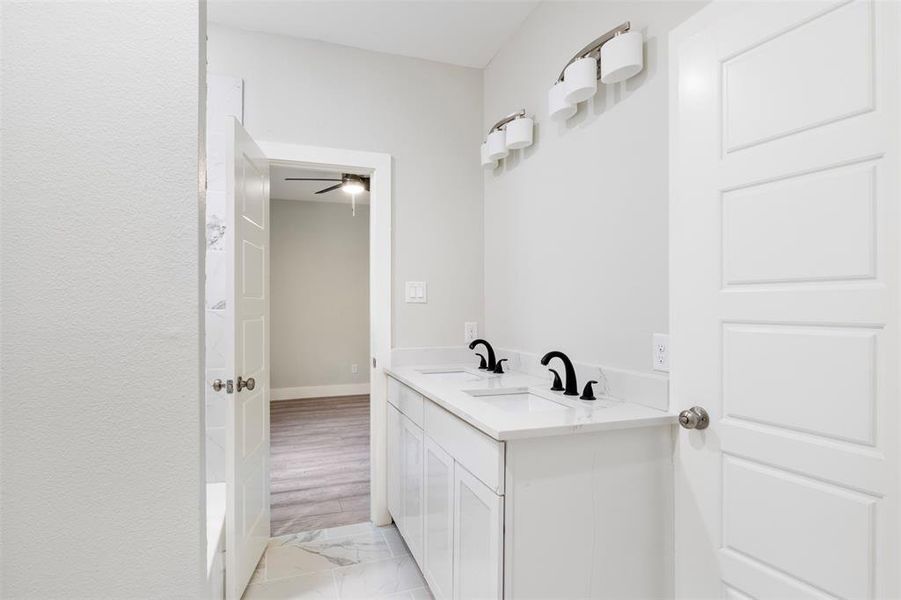 Bathroom with tile floors, ceiling fan, and dual bowl vanity