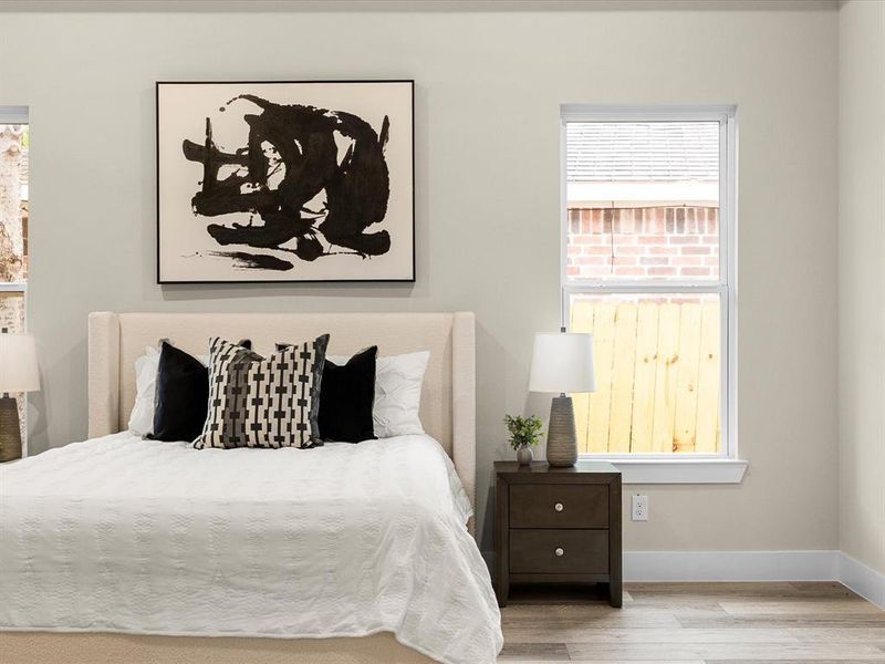 Bedroom with wood finished floors and baseboards