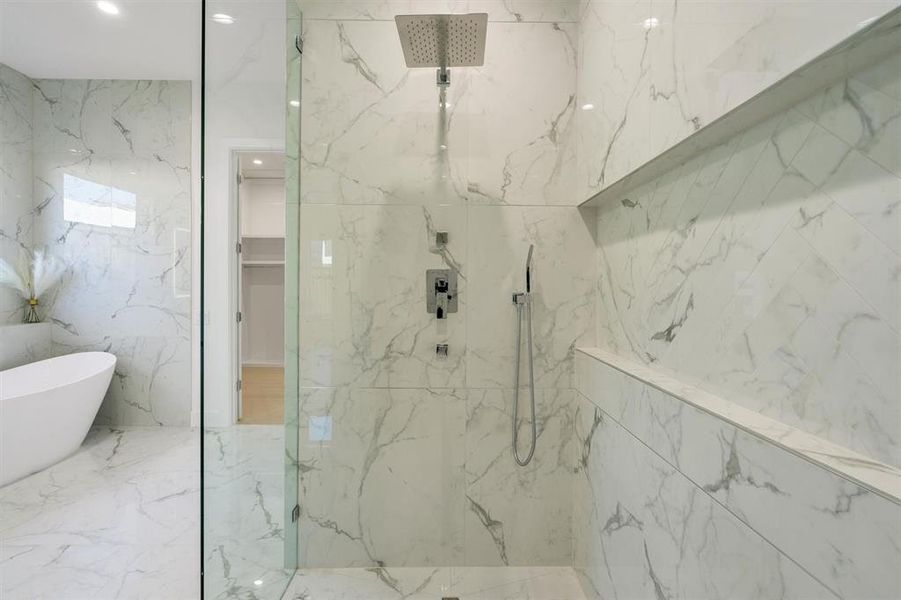 Bathroom featuring a marble finish shower, a spacious closet, a freestanding bath, and recessed lighting