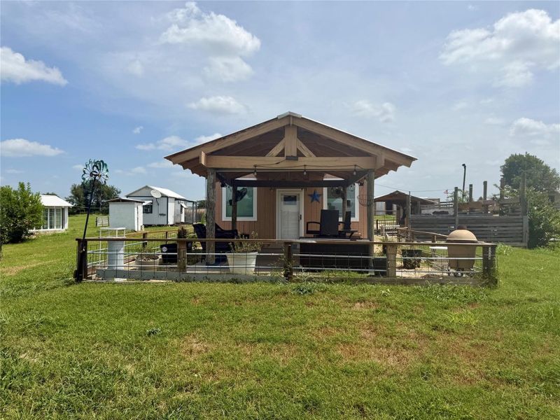 An inviting porch and expansive lawn frame this charming rural home.