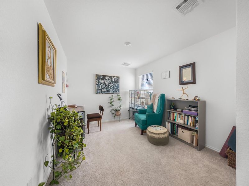 Living area with light colored carpet and baseboards