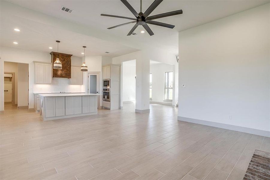 Unfurnished living room with ceiling fan and light hardwood / wood-style flooring