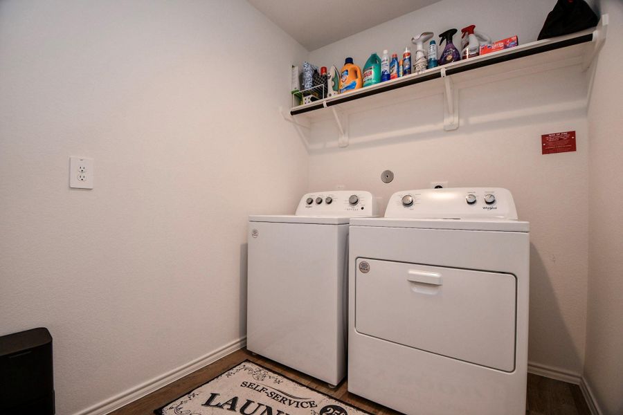 This laundry room is set with a shelf above for storage conveniently located by the three bedrooms at the front of the home