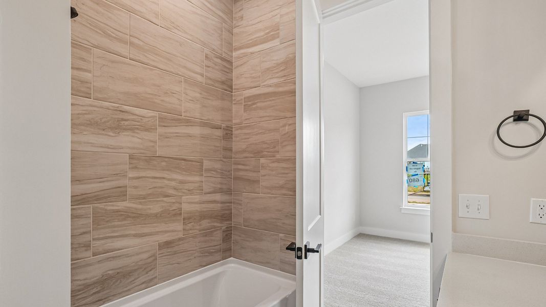 Guest bathroom with tile flooring and shower and walk-in closet