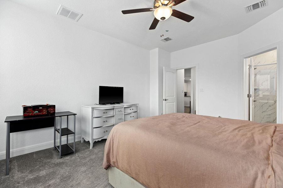 A comfortable bedroom with soft carpeting and a ceiling fan, offering a tranquil retreat.