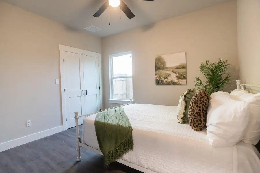 Bedroom featuring dark wood-style flooring, baseboards, ceiling fan, and a closet Bedroom featuring dark wood-style flooring, baseboards, ceiling fan, and a closet